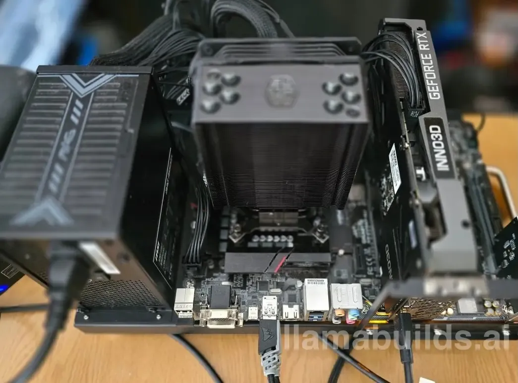 Open test bench on a wooden desk with an Inno3D GeForce RTX 3060, a black tower air cooler, an exposed micro-ATX motherboard, and a power supply sitting beside it.